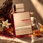 Amber Oud Rouge Al Haramain Eau de Parfum con fondo de ingredientes creativo